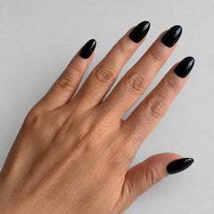 Nailora Jet Black Glossy Short Almond Press-On Nails featuring a rich black shade with a reusable salon-quality finish for everyday wear, evening style, and modern minimalist fashion.