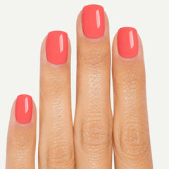 Close-up of Peach Glow short square press-on nails showing peach coral glossy finish