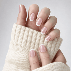 Blush Veil short square press-on nails with blush pearl French tips styled with a beige sweater