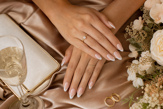 Nude French almond press-on nails styled with a camel wedding guest dress
