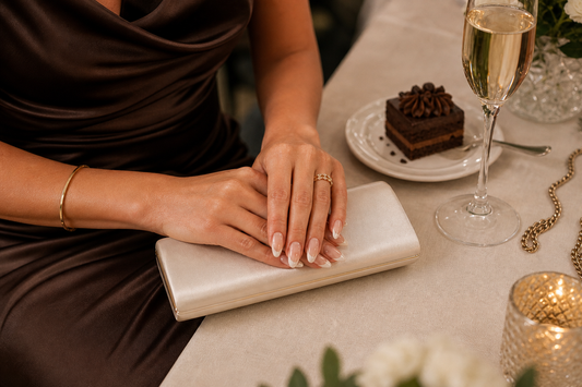 Nude French almond press-on nails styled with a chocolate wedding guest dress