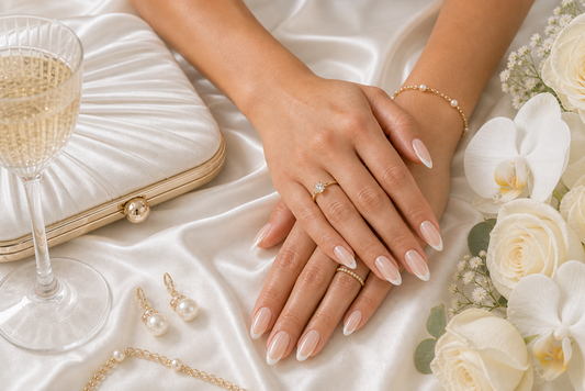 Sheer nude French almond press-on nails styled with a diamond white wedding guest dress