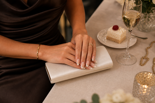 Nude French almond press-on nails styled with an espresso wedding guest dress