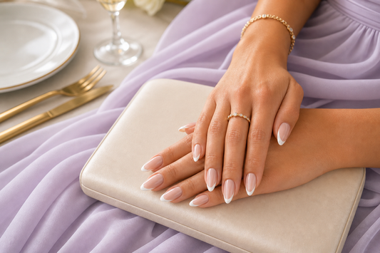 Nude French almond press-on nails styled with a lilac wedding guest dress