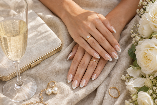Creamy nude French almond press-on nails styled with a linen wedding guest dress