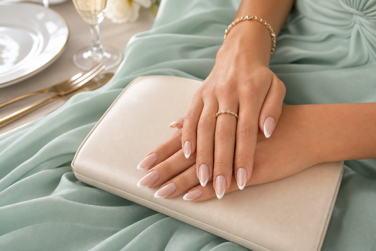 Nude French almond press-on nails styled with a mint green wedding guest dress