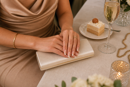 Nude French almond press-on nails styled with a tan wedding guest dress