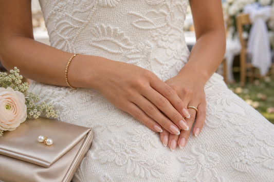 Warm nude French almond press-on nails styled with a textured white wedding guest dress