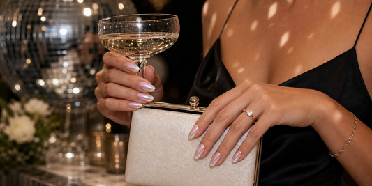 Pink chrome press-on nails holding a clutch at a wedding after-party