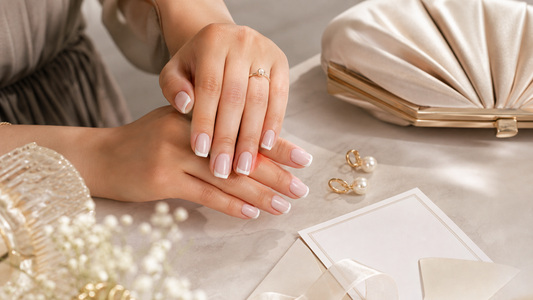 Wedding guest wearing nude French press-on nails with pearl shimmer for an elegant event manicure