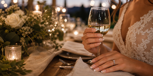 Glazed French press-on nails holding a wine glass at a winery wedding reception