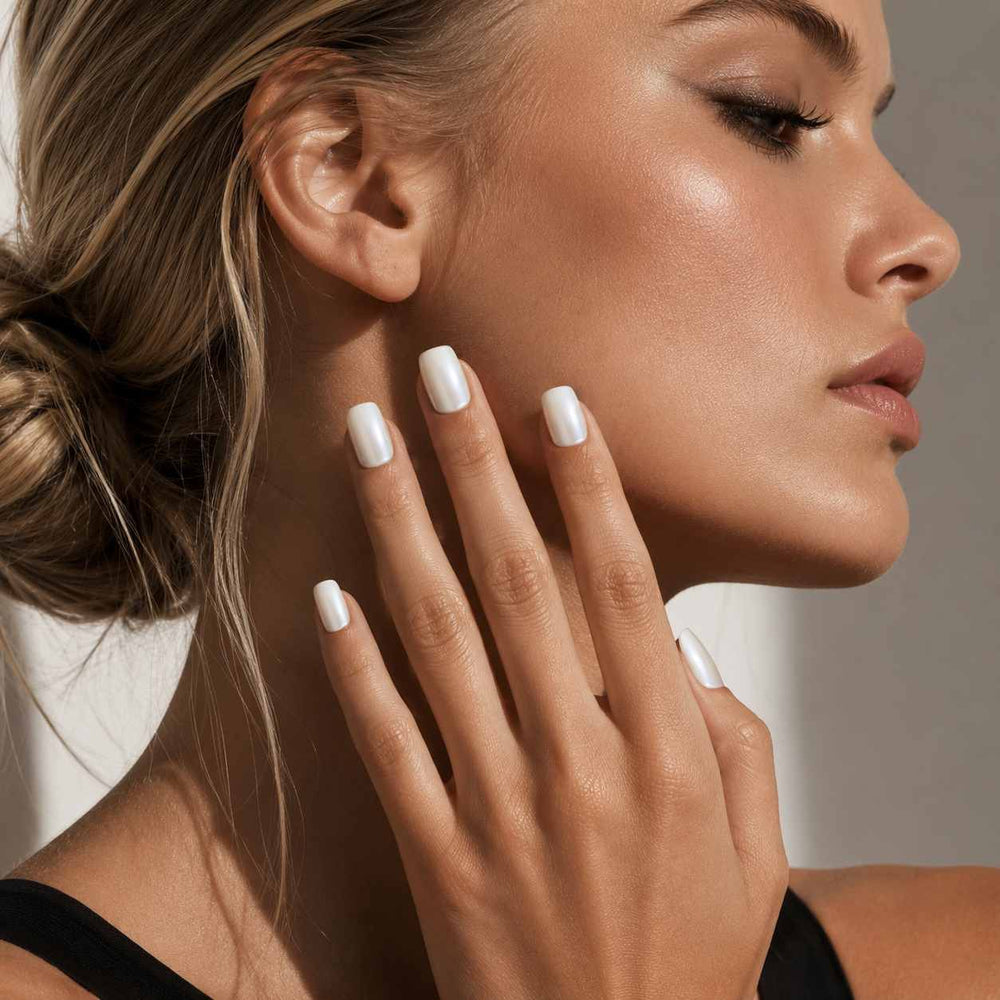 Female model wearing Nailora Pearl White Short Square Press-On Nails featuring luminous pearl shine and elegant minimalist manicure style
