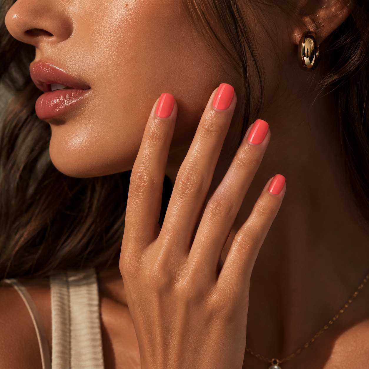 Model wearing Peach Glow peach coral glossy short square press-on nails