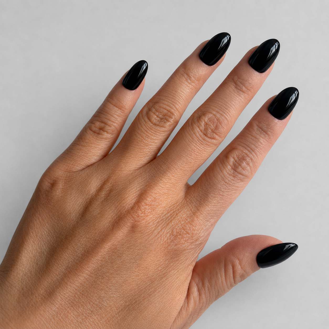 Nailora Jet Black Glossy Short Almond Press-On Nails featuring a rich black shade with a reusable salon-quality finish for everyday wear, evening style, and modern minimalist fashion.