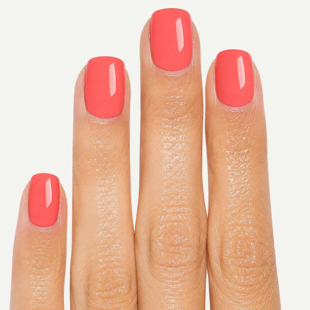Close-up of Peach Glow short square press-on nails showing peach coral glossy finish