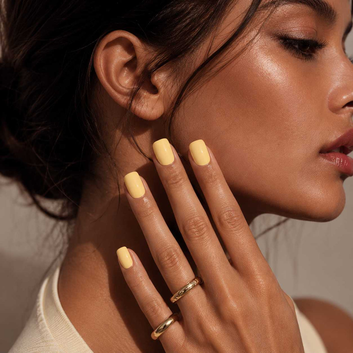 Female model wearing Nailora Lemon Sorbet Glossy Square Press-On Nails featuring cheerful lemon yellow tones and elegant square-shaped manicure style