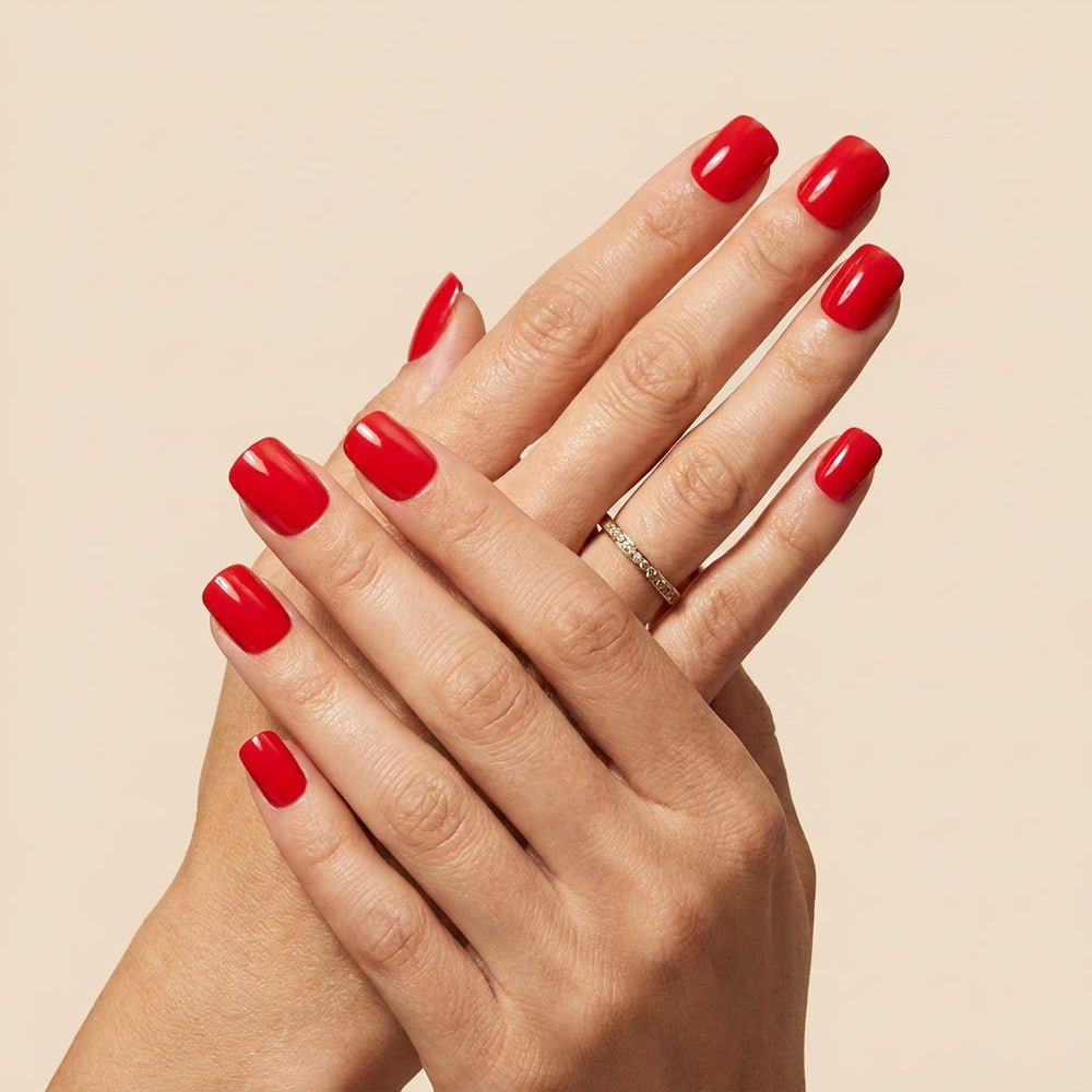 Close-up of Cherry Muse cherry red glossy short square press-on nails on hand