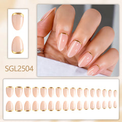 Minimalist almond-shaped nude press-on nails with glossy finish and fine gold outline detail on each nail.