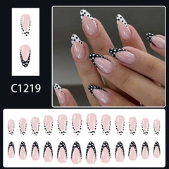 Elegant nude almond nails with glossy finish and black French tip design decorated with white polka dots.