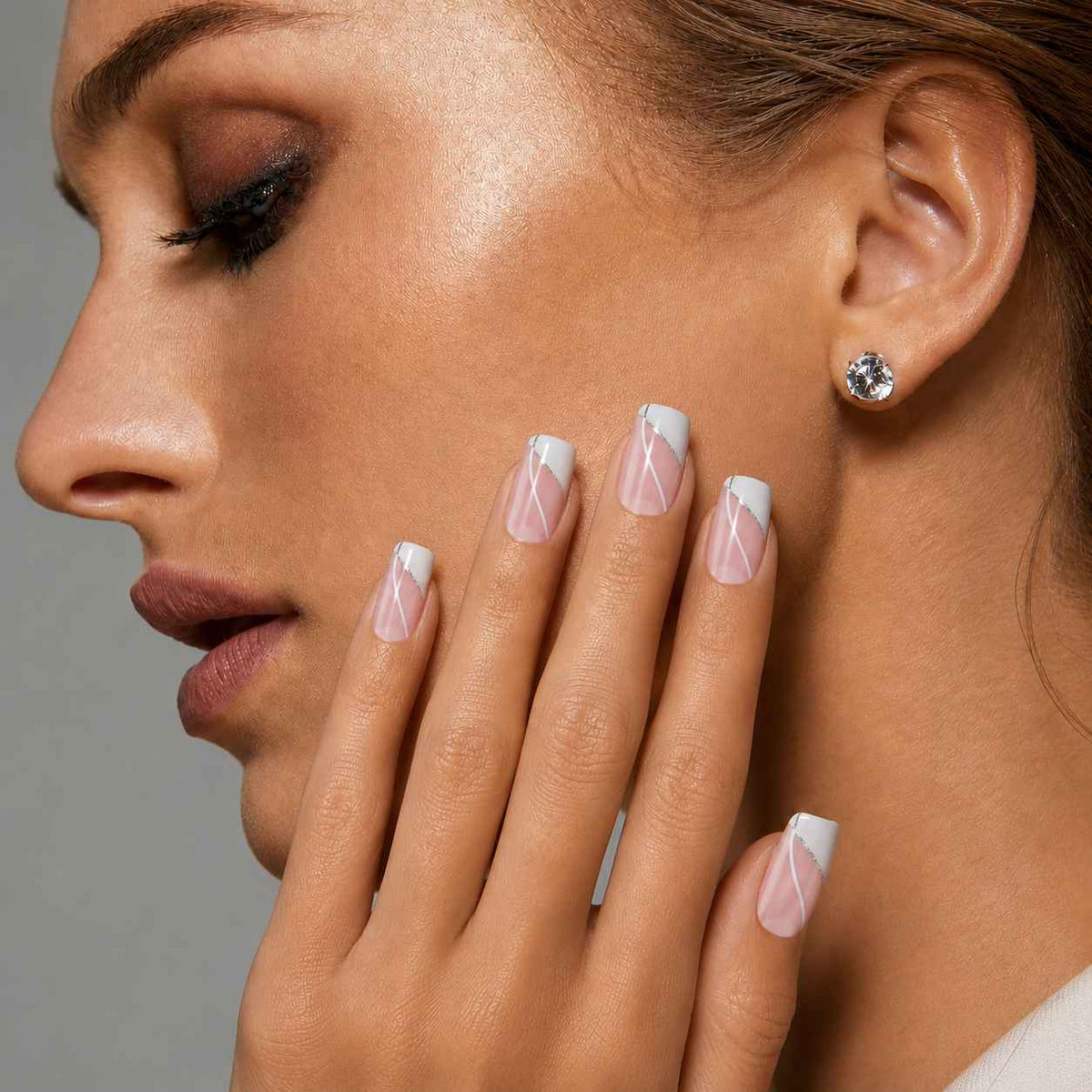 Model wearing Ivory Spark short ballerina press-on nails with white French tips and glitter line accents