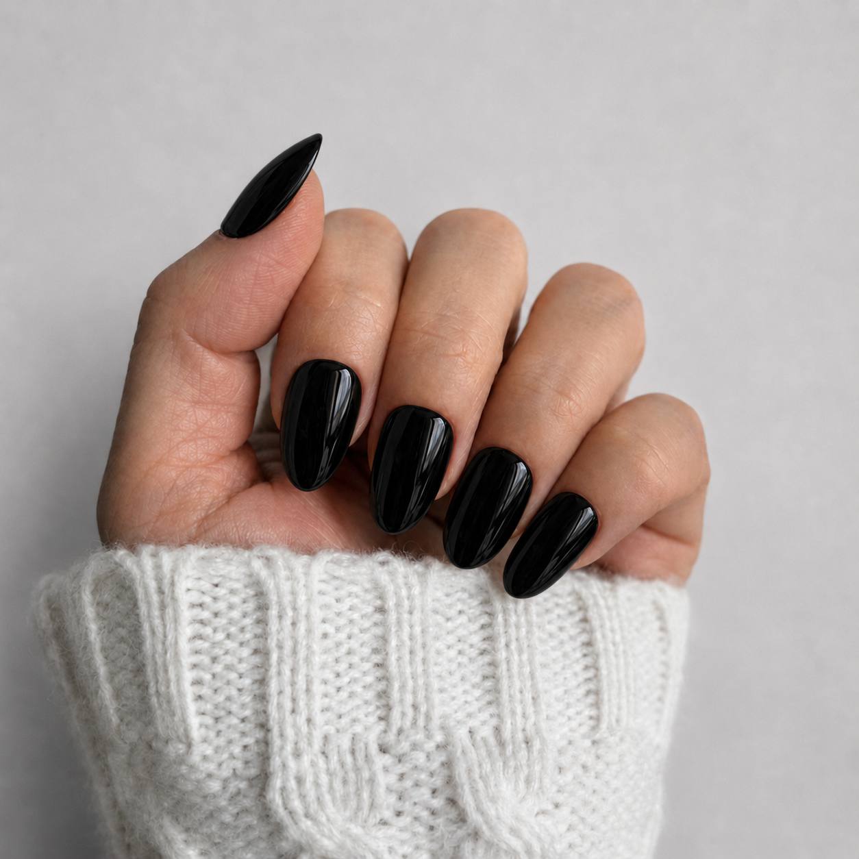 Nailora Jet Black Glossy Short Almond Press-On Nails featuring a rich black shade with a reusable salon-quality finish for everyday wear, evening style, and modern minimalist fashion.