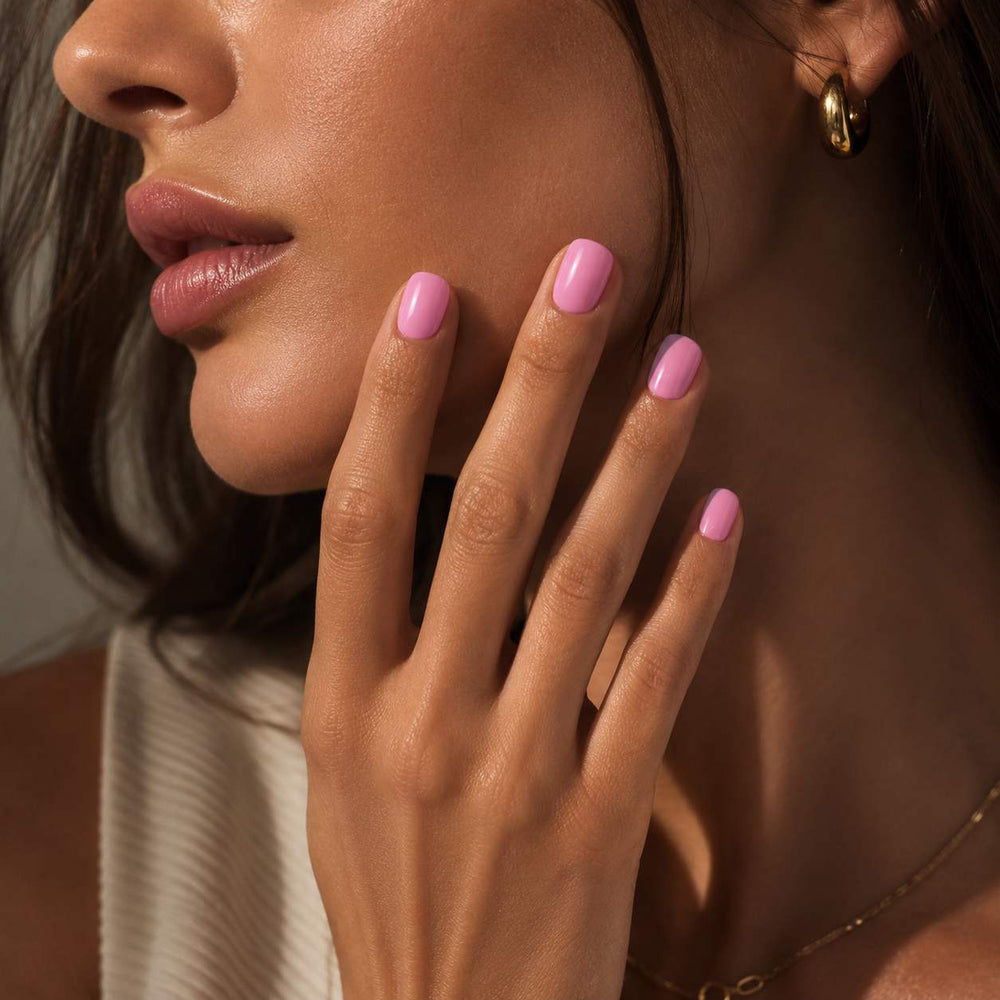 Female model wearing Nailora Bubblegum Pink Glossy Short Square Press-On Nails featuring soft pink tones and elegant short square manicure style