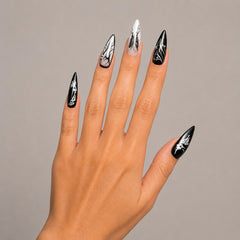 Close-up of gothic stiletto press-on nails in glossy black with midnight veil design details